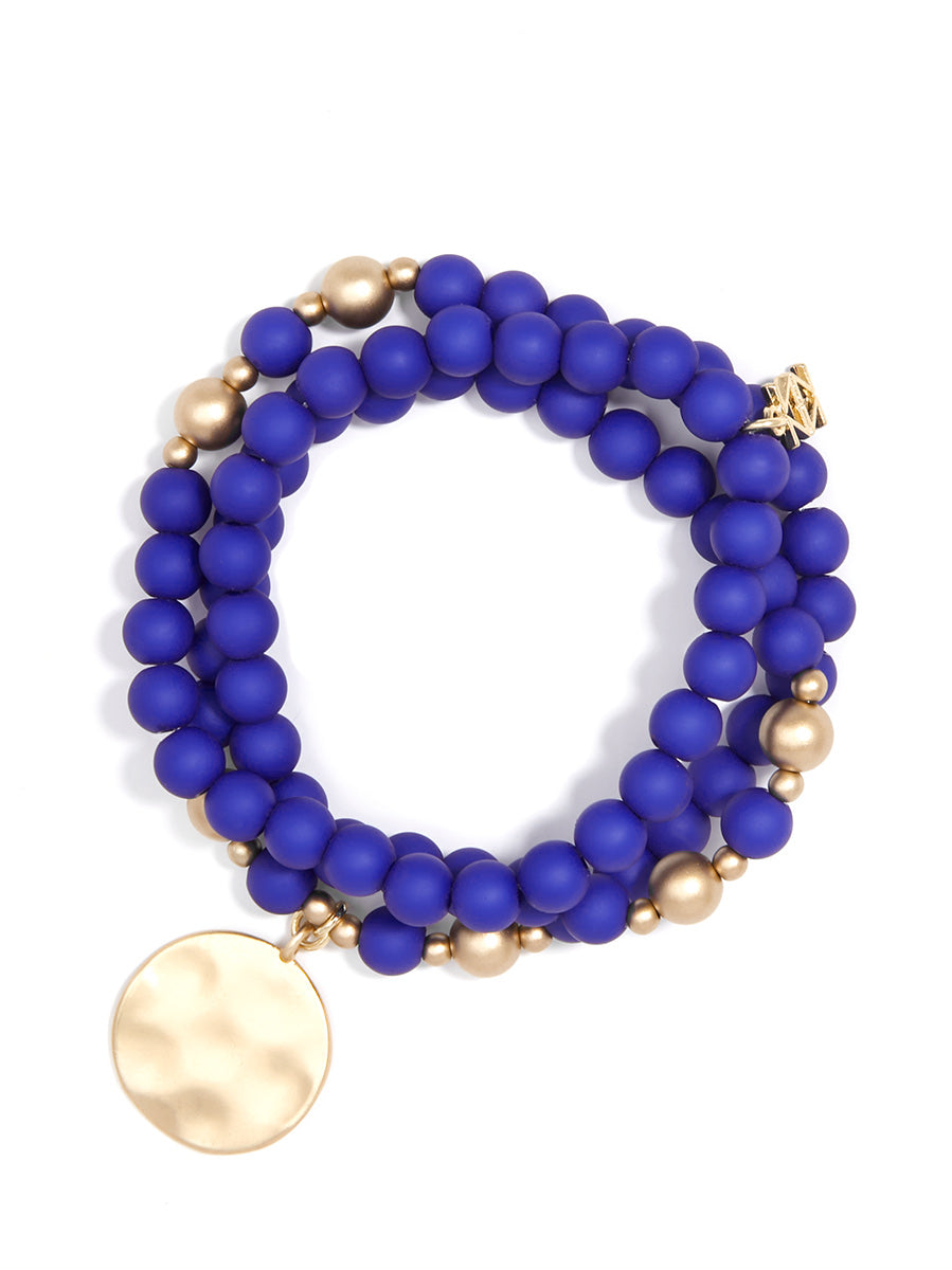 Wrap stretch, COBALT, bracelet composed of matte beads and a hammered, matte gold coin charm.