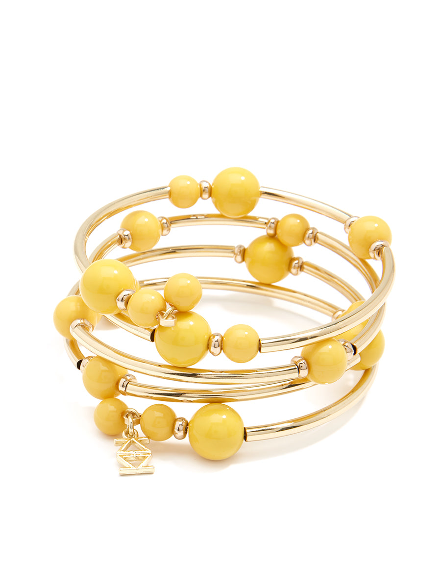 Shiny metal yellow coil bracelet with metal and glossy resin beaded accents